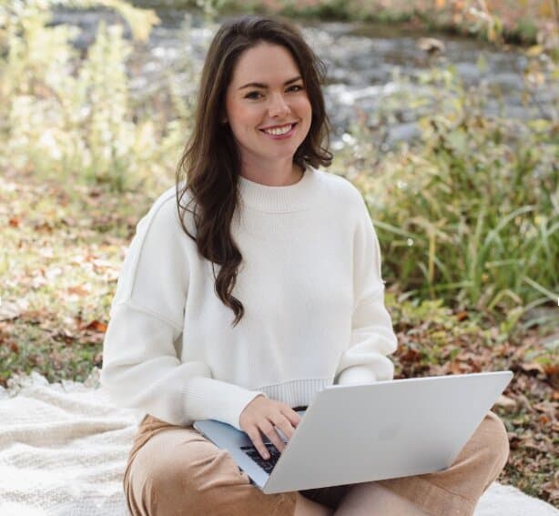 Emily working on a laptop outdoors, smiling